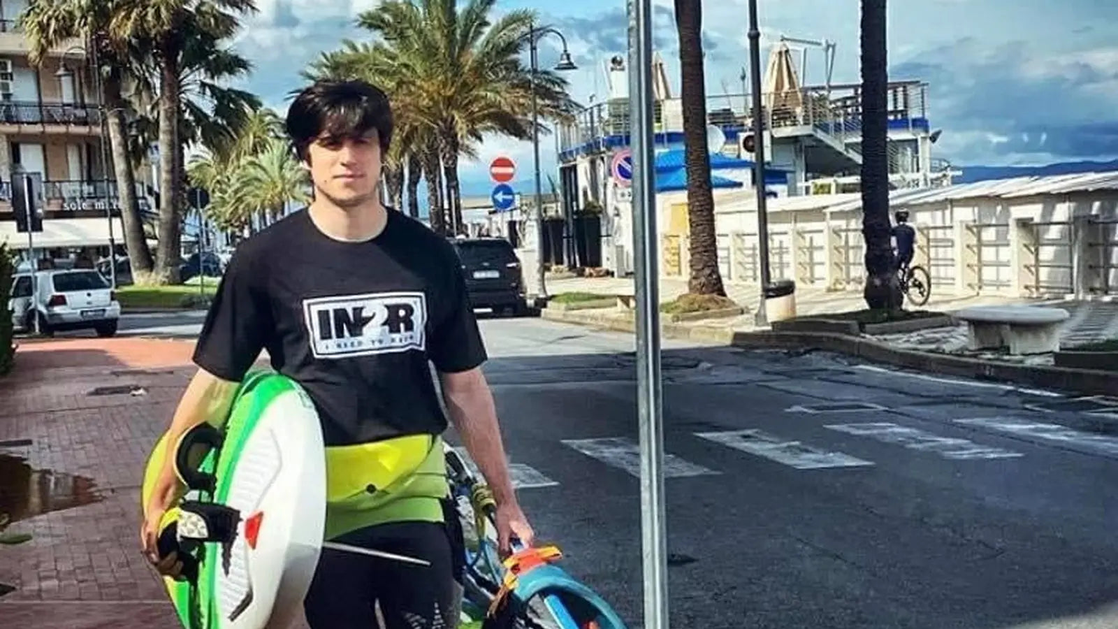 IN2R Ambassador Marco carrying windsurfing gear while wearing an IN2R T-shirt