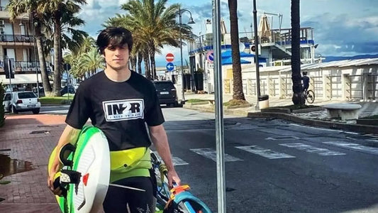 IN2R Ambassador Marco carrying windsurfing gear while wearing an IN2R T-shirt