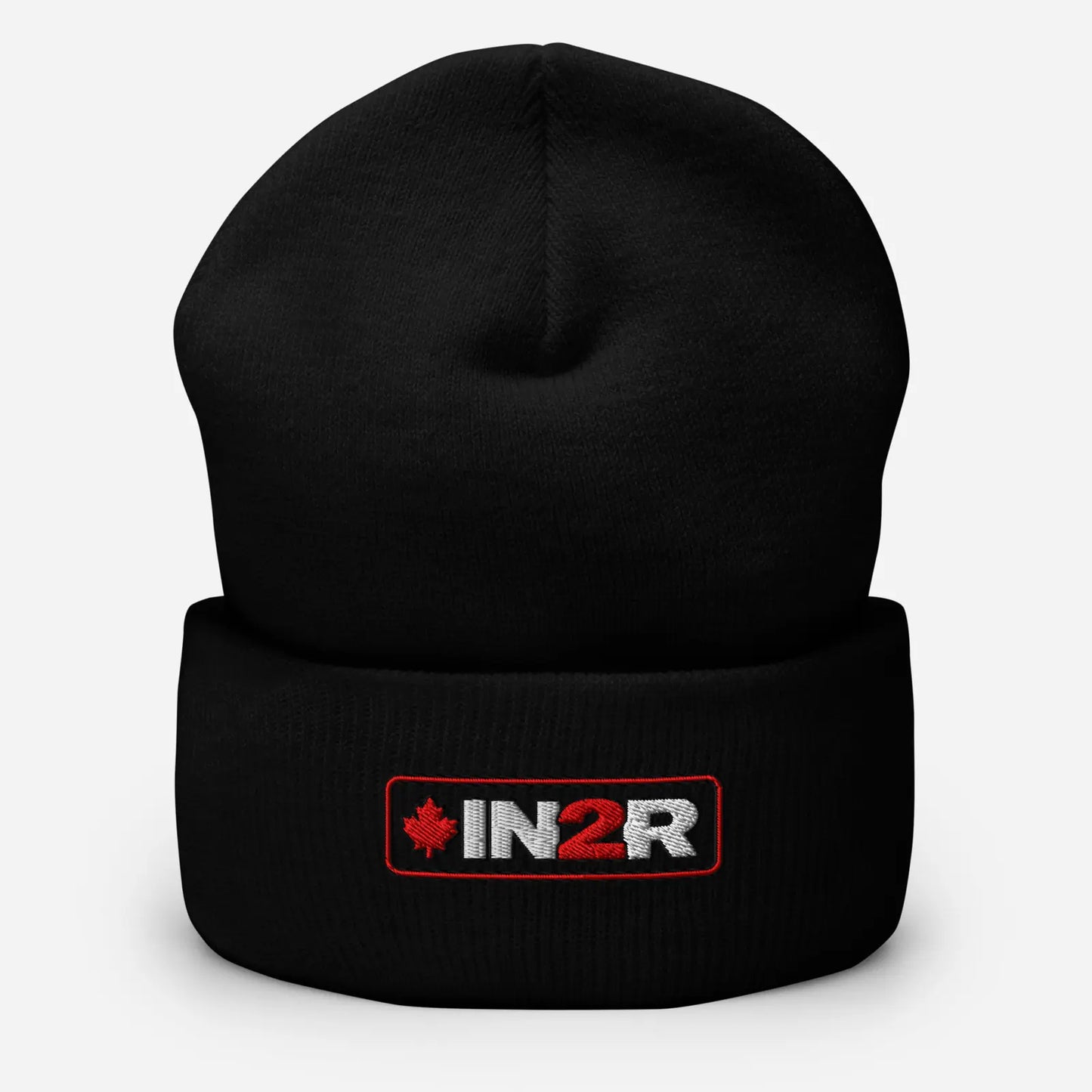 A black knit cuffed beanie hat featuring a rectangular embroidered logo patch on the front cuff with the text 'IN2R' in white and red, alongside a small red maple leaf, set against a light gray background.
