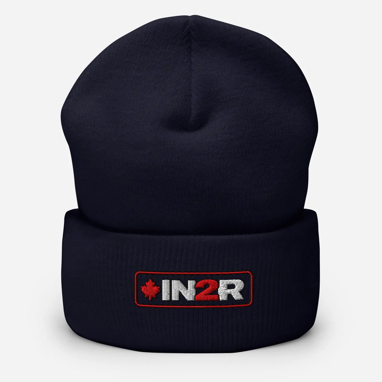 A dark navy blue knit beanie hat with a folded cuff, featuring an embroidered IN2R logo patch with a red maple leaf on the front, set against a light gray background.
