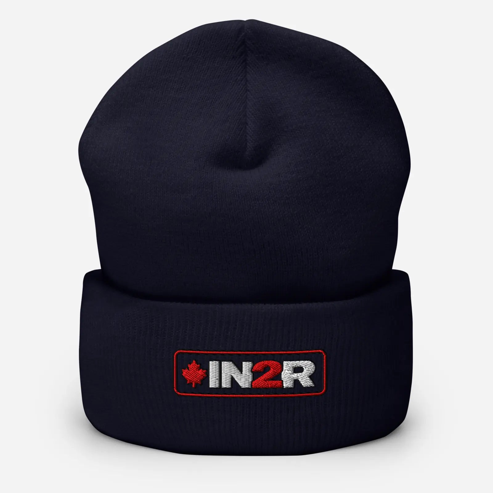 A dark navy blue knit beanie hat with a folded cuff, featuring an embroidered IN2R logo patch with a red maple leaf on the front, set against a light gray background.