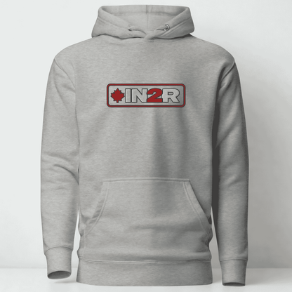 A light gray heather pullover hoodie with a front kangaroo pocket and a chest graphic that reads 'IN2R' with a red maple leaf and red border, shown on a plain light gray background.