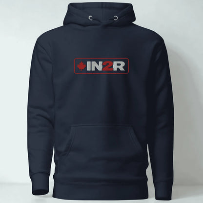 A navy blue pullover hoodie with a front kangaroo pocket and a chest graphic that reads 'IN2R' with a red maple leaf, shown against a light gray background.