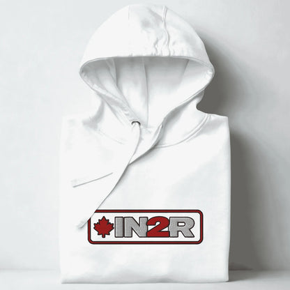 A folded white hoodie with a drawstring hood, featuring a red and gray 'IN2R' logo with a maple leaf on the chest, set against a light gray background.