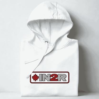 A folded white hoodie with a drawstring hood, featuring a red and gray 'IN2R' logo with a maple leaf on the chest, set against a light gray background.