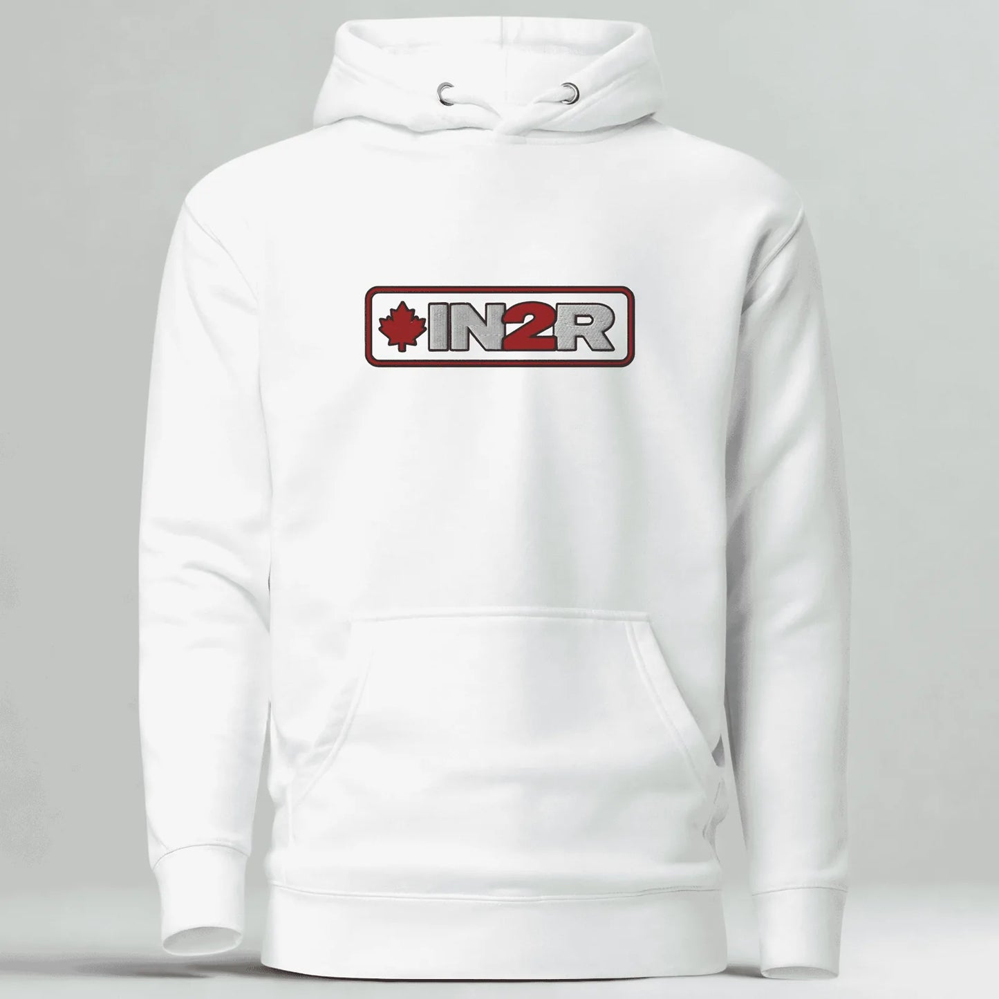 A white pullover hoodie with a front kangaroo pocket and a chest graphic that reads 'IN2R' with a red maple leaf icon, shown on a light gray background.