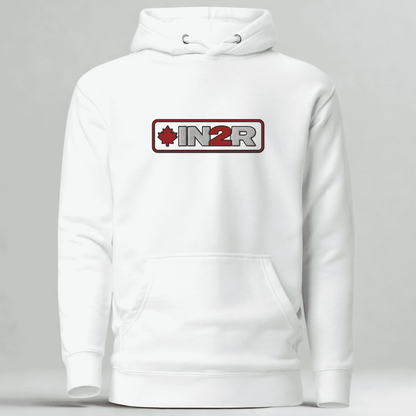 A white pullover hoodie with a front kangaroo pocket and a chest graphic that reads 'IN2R' with a red maple leaf and red border, shown on a light gray studio background.