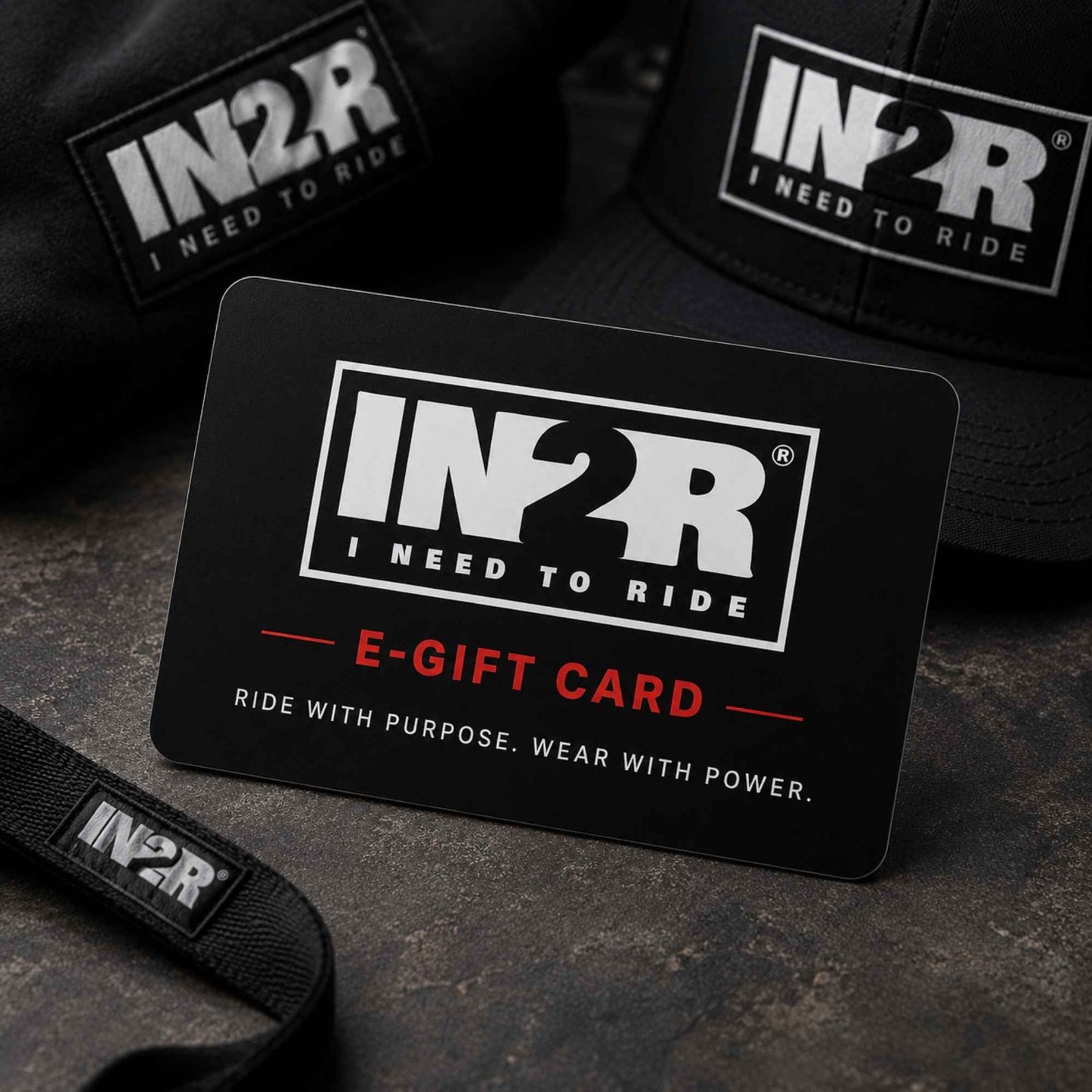 A black IN2R e-gift card with white and red text reading 'E-GIFT CARD' and 'RIDE WITH PURPOSE. WEAR WITH POWER.