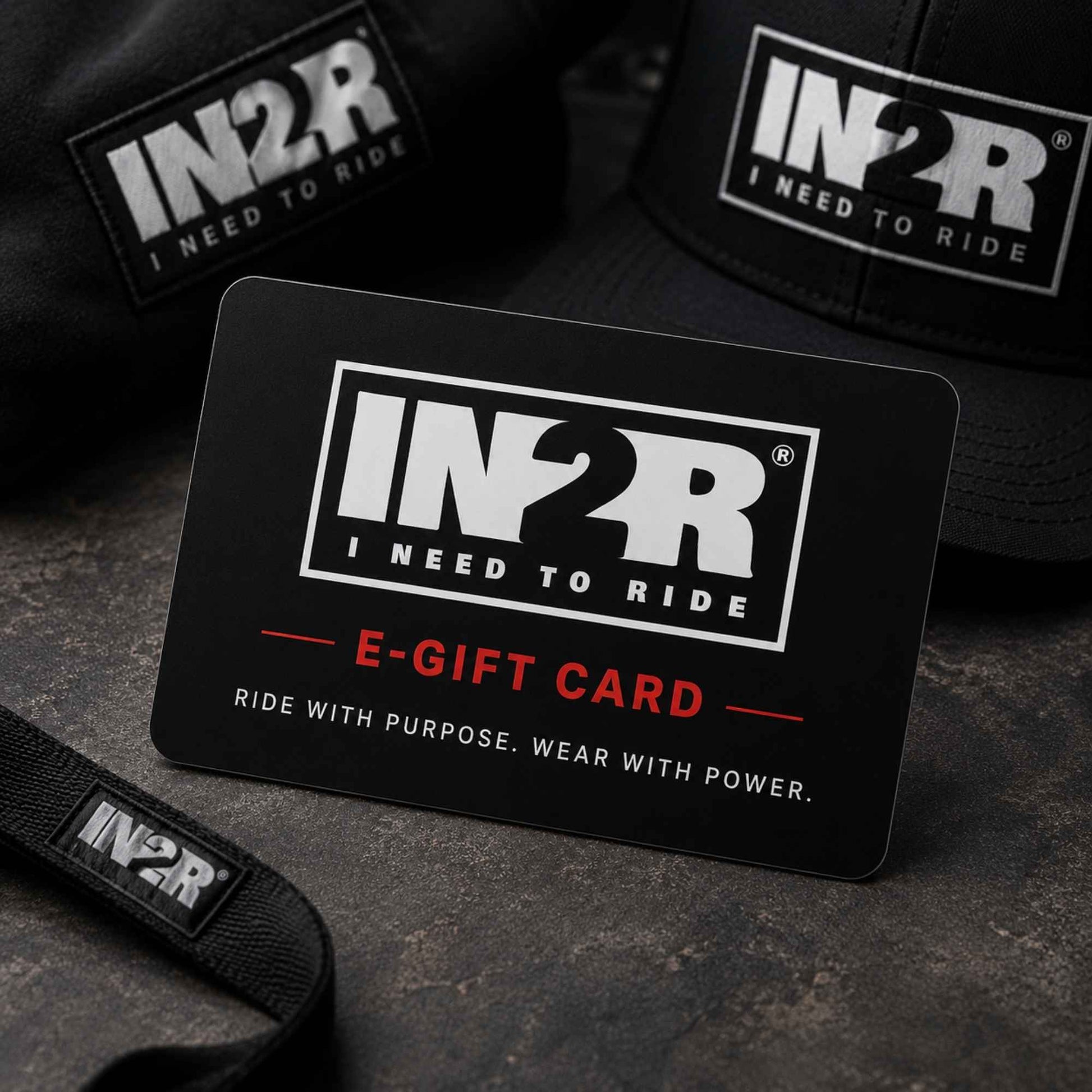 A black IN2R e-gift card with white and red text reading 'E-GIFT CARD' and 'RIDE WITH PURPOSE. WEAR WITH POWER.