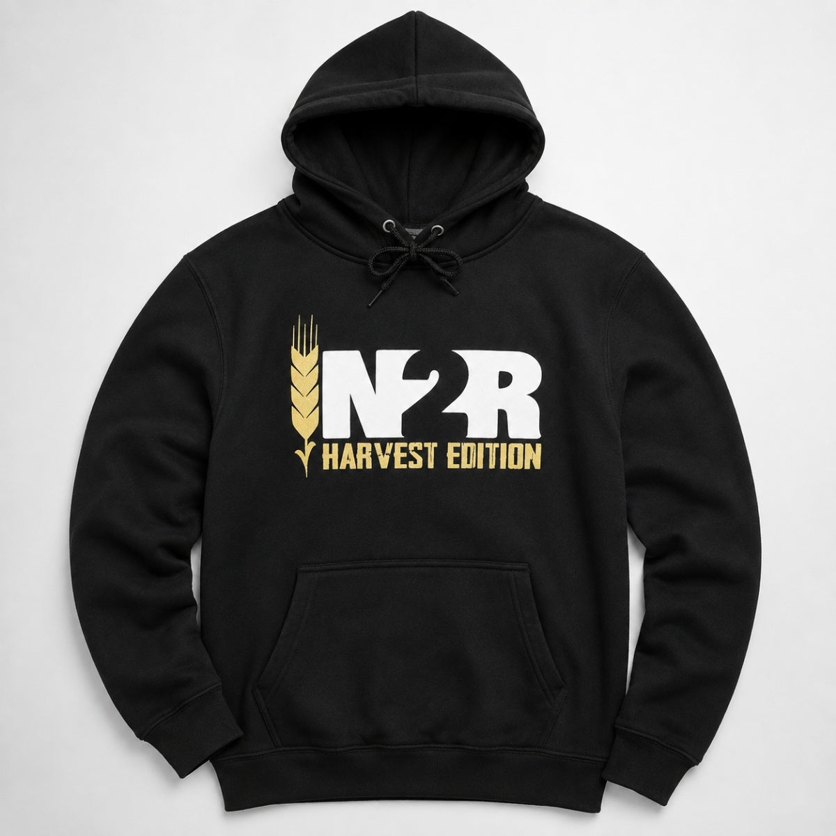 A black pullover hoodie with a front kangaroo pocket and drawstring hood, featuring a large white and gold 'IN2R HARVEST EDITION' graphic on the chest, displayed against a light gray background.