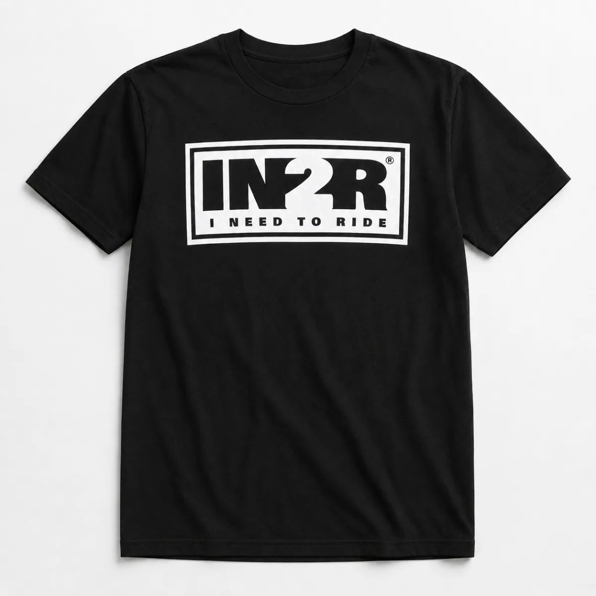 A black short-sleeve crewneck t-shirt featuring a bold white graphic on the chest with the letters 'IN2R' and the text 'I NEED TO RIDE' underneath, displayed against a clean white background.