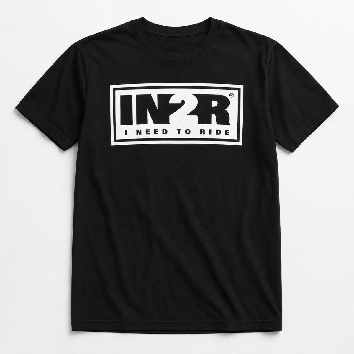 A black short-sleeve crewneck t-shirt with a white rectangular graphic on the chest featuring the stylized letters 'IN2R' and the text 'I NEED TO RIDE'.
