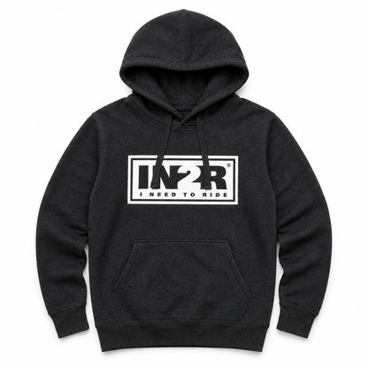 A dark charcoal gray heather pullover hoodie with a white rectangular graphic on the chest featuring the stylized letters 'IN2R' and the text 'I NEED TO RIDE'. The hoodie has a front kangaroo pocket and drawstring hood, shown against a plain white background.