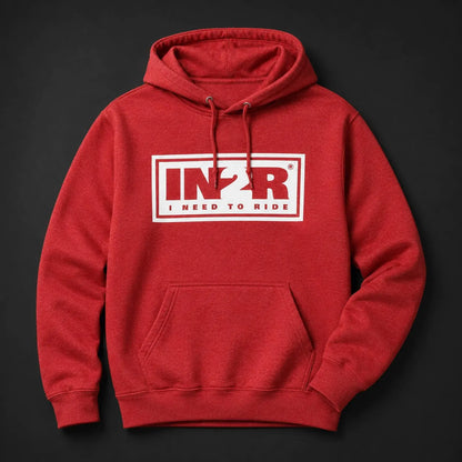 A red pullover hoodie with a white rectangular chest graphic reading 'IN2R I NEED TO RIDE' in red and white, shown on a dark charcoal background.
