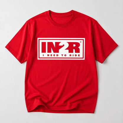 A red short-sleeve crewneck t-shirt with a white graphic print on the chest reading 'IN2R I NEED TO RIDE' inside a white rectangular border, shown on a light gray background.