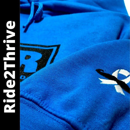 Close-up of a bright blue hoodie fabric with a black embroidered logo and a white ribbon graphic, plus a vertical black sidebar with the text Ride2Thrive.